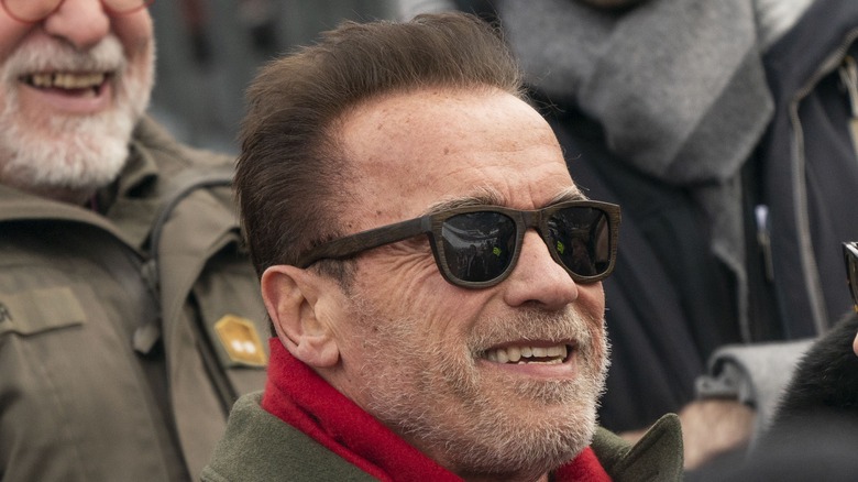 Arnold Schwarzenegger souriant dans des lunettes de soleil