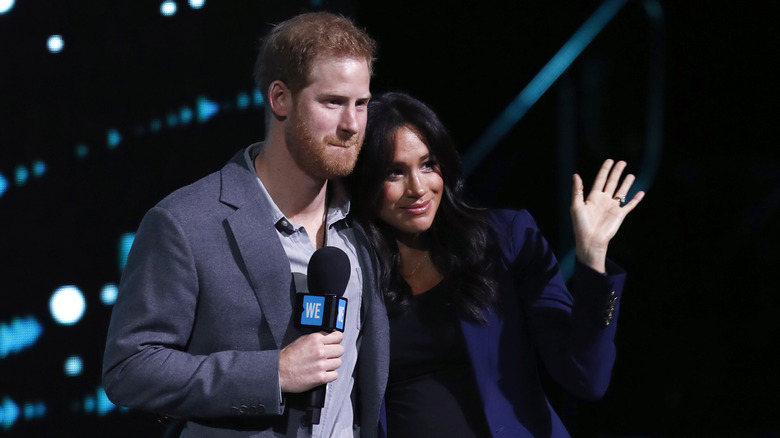 Le prince Harry et Meghan Markle sourient sur scène lors d'un événement