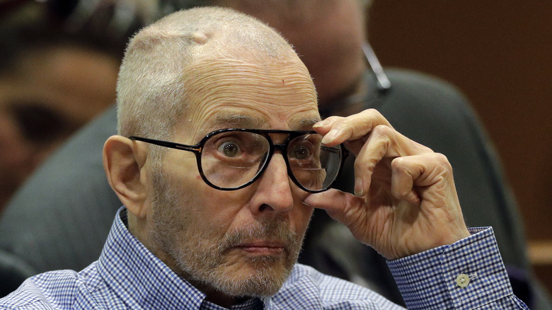 Robert Durst ajustant ses lunettes