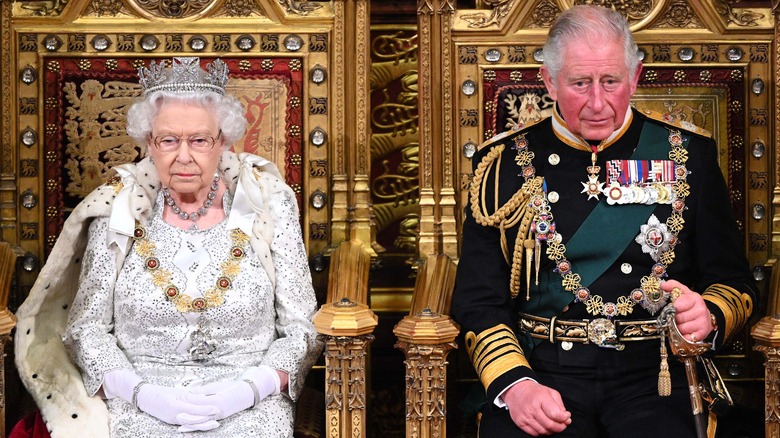 La reine Elizabeth et le prince Charles assis sur des trônes