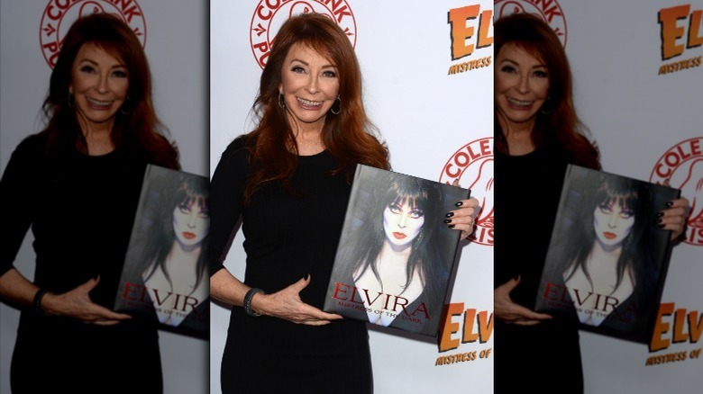 Cassandra Peterson tient le livre d'Elvira