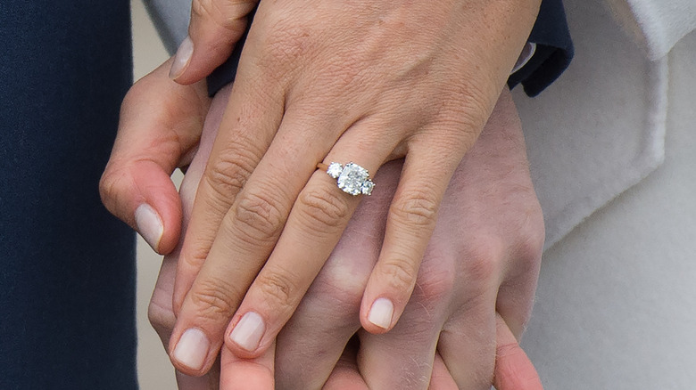 Meghan Markle wearing her engagement ring, holding hands with Harry