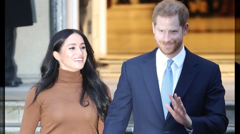 Meghan Markle smiles, Prince Harry waves