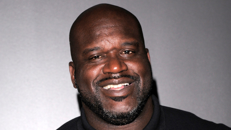 Shaquille O'Neal souriant dans un polo