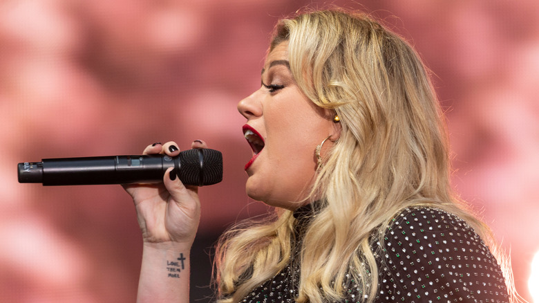 Kelly Clarkson sur scène chantant dans un micro