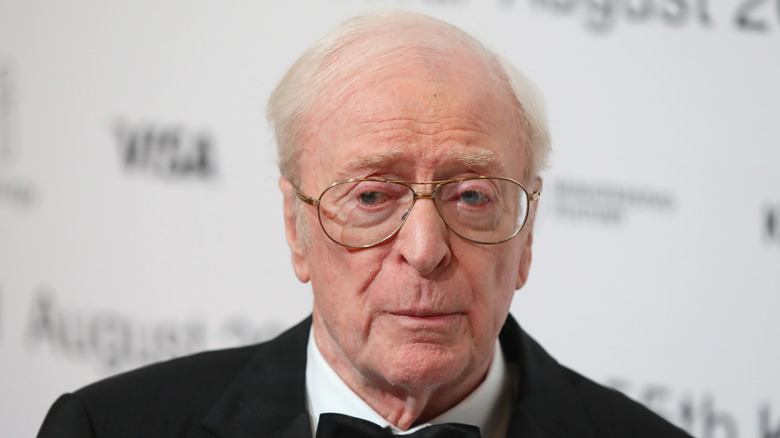 Michael Caine portant des lunettes avec une expression sérieuse