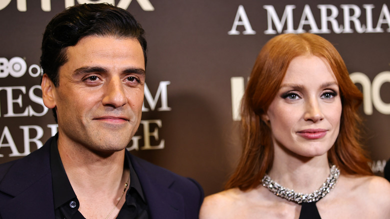 Oscar Isaac et Jessica Chastain souriant sur le tapis rouge lors d'un événement 