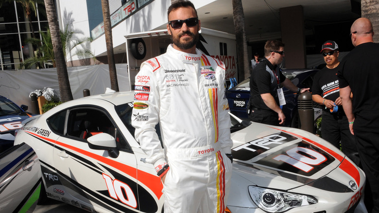 Brian Austin Green debout à côté d'une voiture de course