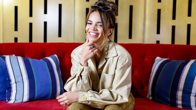 Leslie Grace smiling on a couch