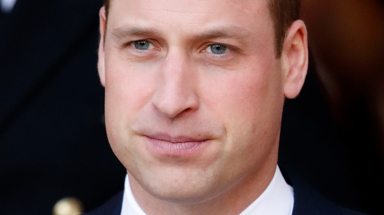 Le prince William pose dans un costume sombre.