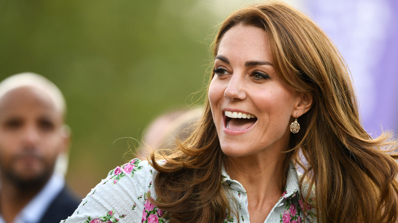 Kate Middleton souriante avec les cheveux au vent