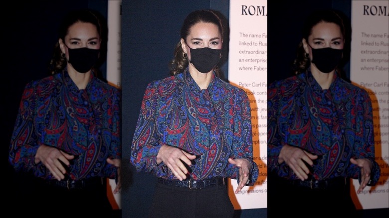 Kate Middleton portant un masque noir et un chemisier cachemire