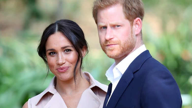 Meghan Markle et le prince Harry réagissent lors d'une sortie