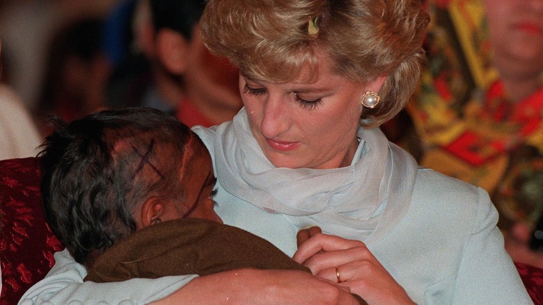 Diana, princesse de Galles, berçant un jeune patient atteint de cancer dans ses bras