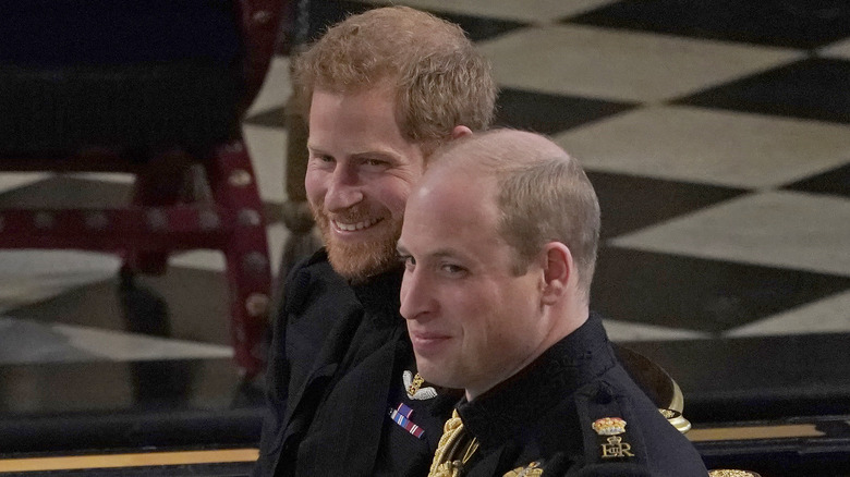 Le prince Harry souriant avec le prince William