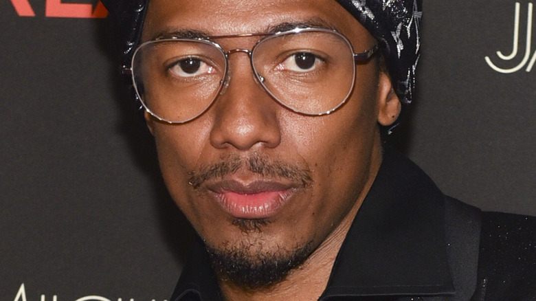 Nick Cannon debout devant un mur noir