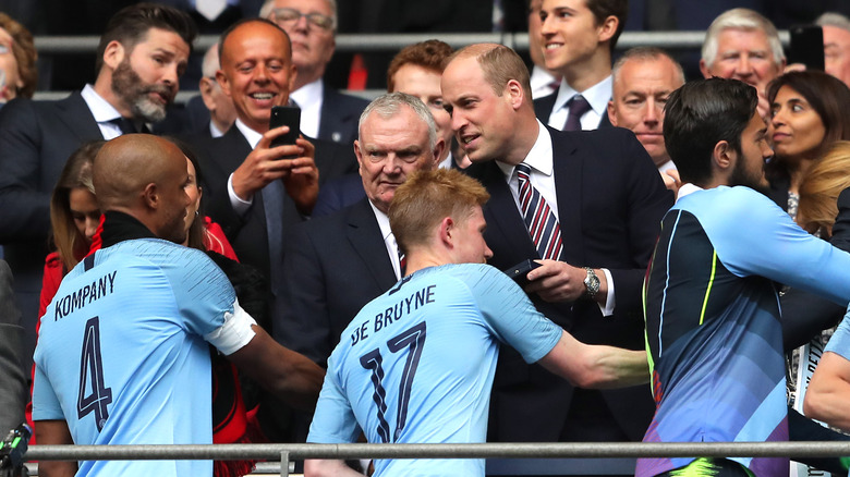 Le prince William saluant une équipe sportive