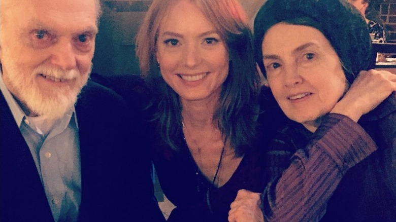 Alicia Witt sourit sur une photo avec ses parents