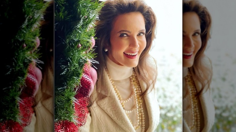 Lynda Carter souriant à côté de l'arbre de Noël