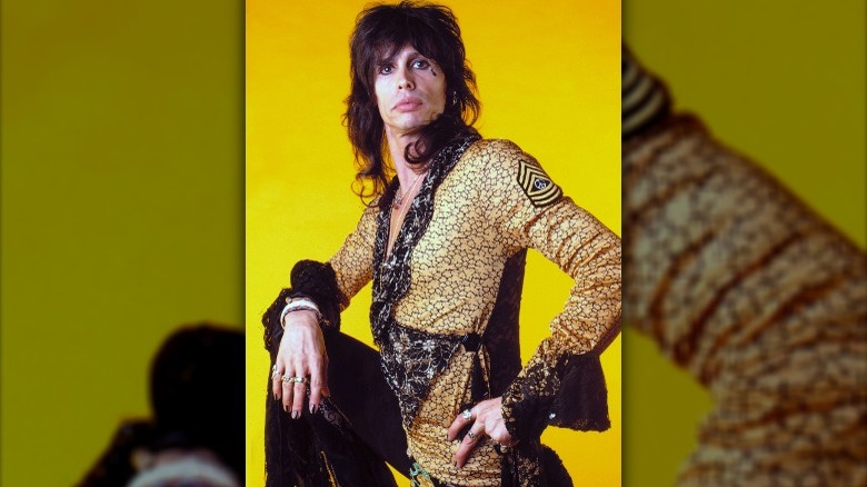 Steven Tyler posant dans une tenue à froufrous jaune des années 80