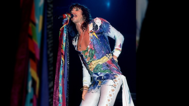 Steven Tyler se produisant dans une combinaison multicolore des années 80