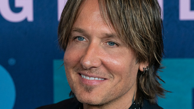 Keith Urban sourit sur le tapis rouge