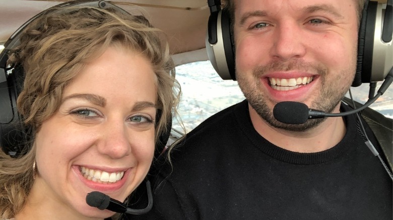 Abbie Burnett et John David Duggar sourient en pilotant un avion