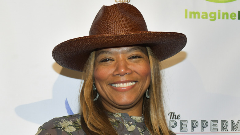 Queen Latifah portant un chapeau marron