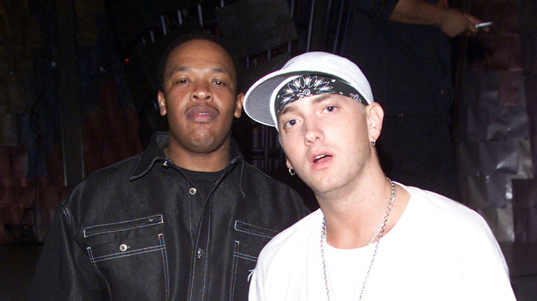 Dr. Dre porte une chemise boutonnée et Eminem porte un t-shirt blanc