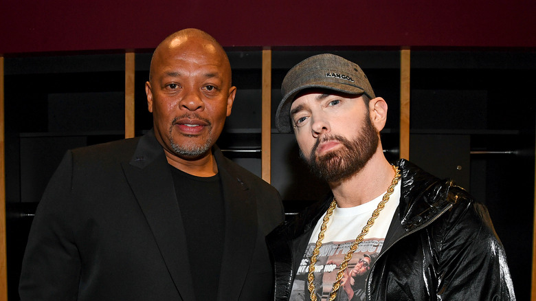 Dr. Dre porte un blazer noir et Eminem porte une veste en cuir noire