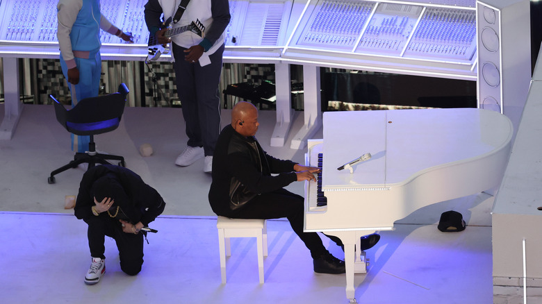 Dr. Dre jouant du piano et Eminem prenant un genou