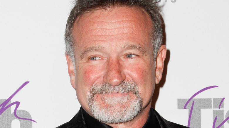 Robin Williams avec des poils sur le visage, souriant