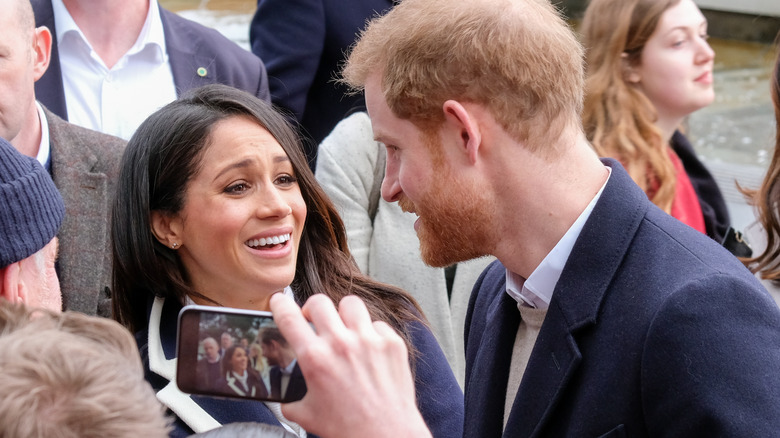 Meghan Markle et le prince Harry se parlent au milieu d'une foule