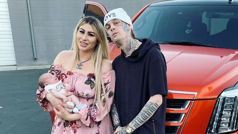 Aaron Carter et Melanie Martin tiennent Prince devant la voiture