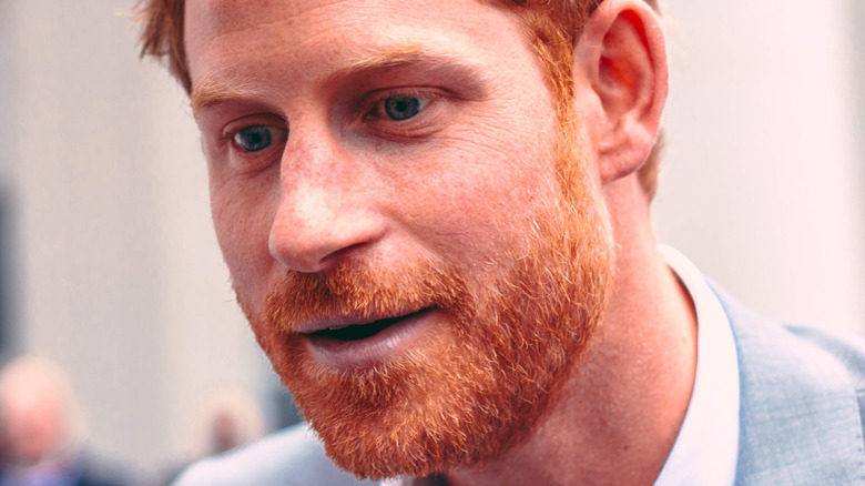 Le prince Harry parle au public en costume gris clair