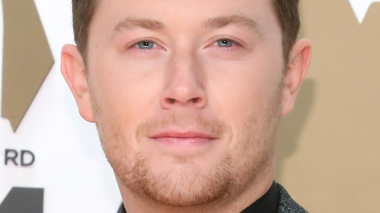 Scotty McCreery souriant sur le tapis rouge