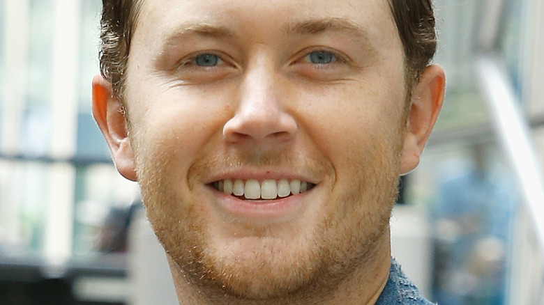 Scotty McCreery souriant sur le tapis rouge