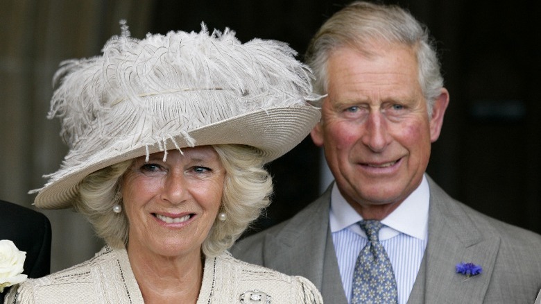 Camilla Parker Bowles dans un chapeau avec le prince Charles debout derrière elle