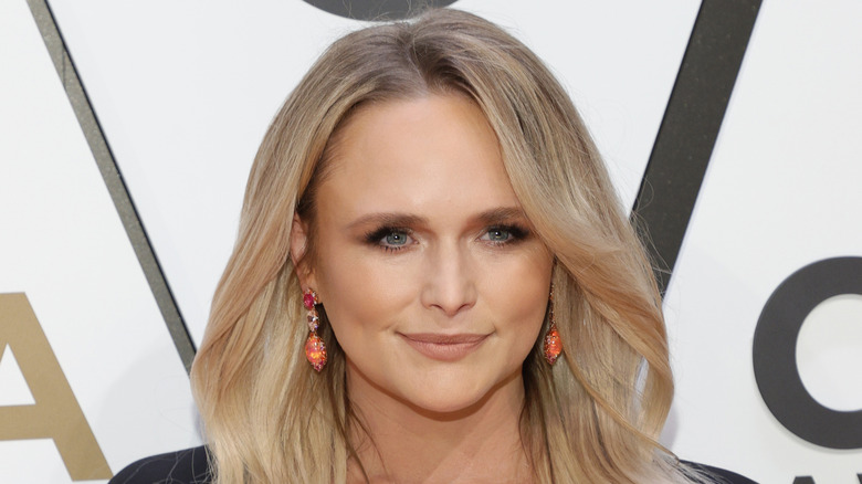 Miranda Lambert porte des boucles d'oreilles pendantes en corail