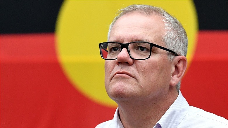 Scott Morrison devant un drapeau aborigène