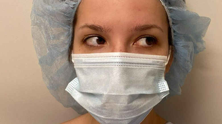 Halsey portant un masque chirurgical et un chapeau