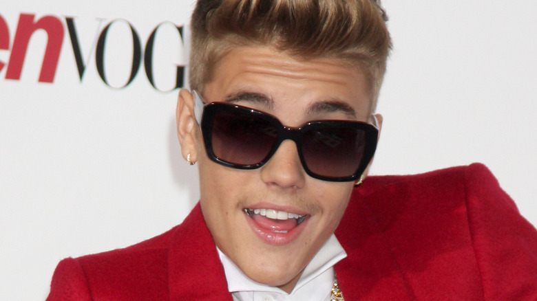 Justin Bieber en lunettes de soleil noires et veste rouge 