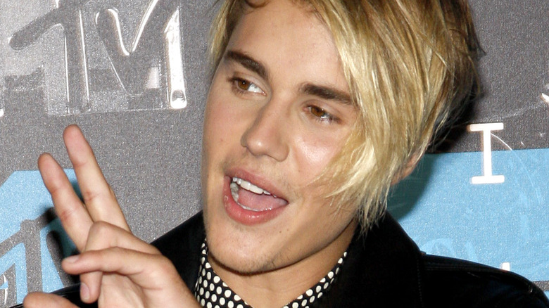 Justin Bieber fait un signe de paix avec les doigts