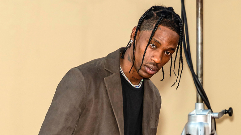 Travis Scott pose dans un blazer marron