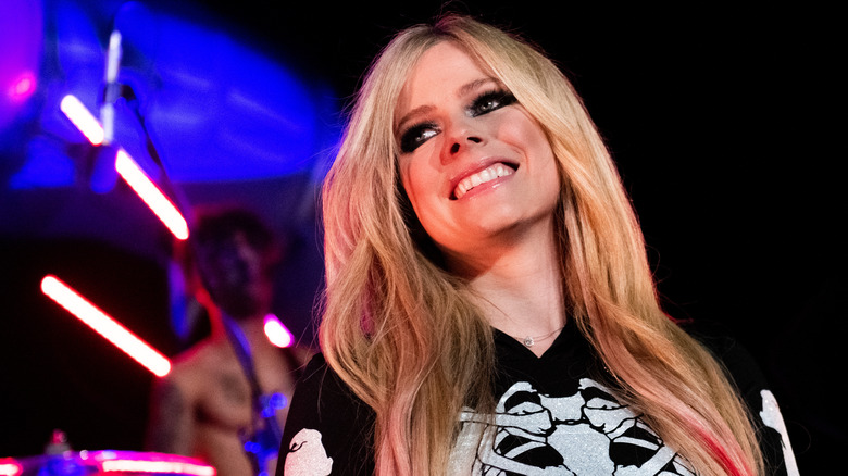 Avril Lavigne souriant sur scène en 2021