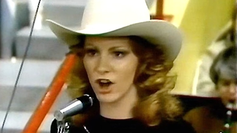 Reba McEntire chantant, coiffée d'un chapeau de cow-boy