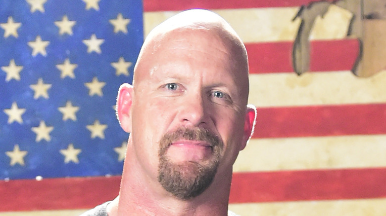 Steve Austin souriant devant le drapeau américain