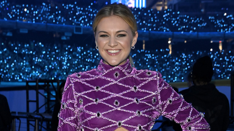 Kelsea Ballerini sourit dans un haut violet