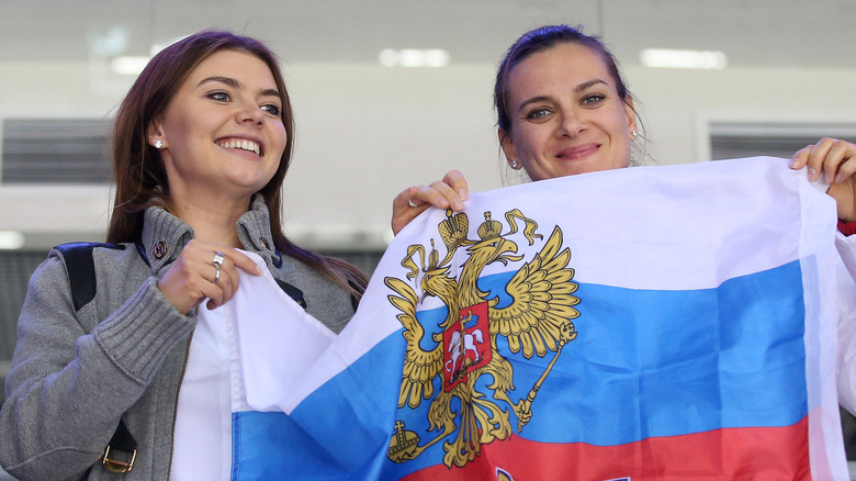 Alina Kabaeva (à gauche) tenant un drapeau aux Jeux olympiques