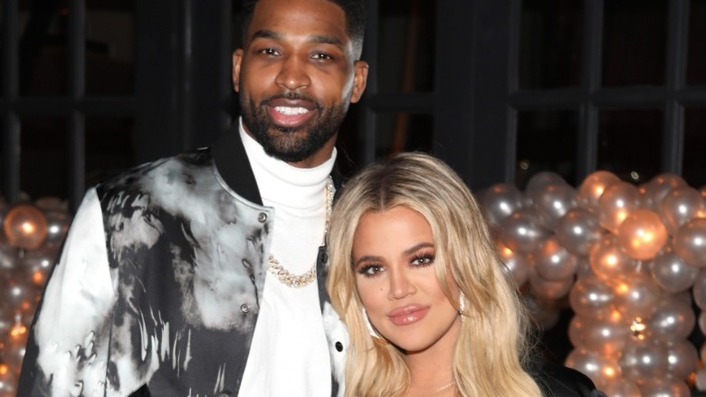 Tristan et Khloe sourient devant des ballons